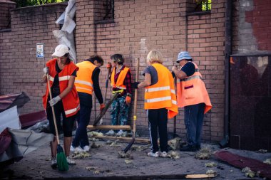 Kharkiv, Ukrayna, 16 Eylül 2025 Temizlik işçileri, Rus Şahin İHA 'sının bir binaya çarptığı sokakta karşılık veriyor. Hasar büyüktü ve bina alev aldı..