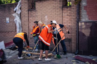 Kharkiv, Ukrayna, 16 Eylül 2025 Temizlik işçileri, Rus Şahin İHA 'sının bir binaya çarptığı sokakta karşılık veriyor. Hasar büyüktü ve bina alev aldı..