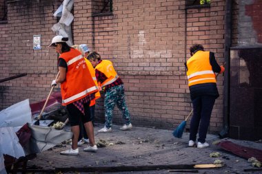 Kharkiv, Ukrayna, 16 Eylül 2025 Temizlik işçileri, Rus Şahin İHA 'sının bir binaya çarptığı sokakta karşılık veriyor. Hasar büyüktü ve bina alev aldı..