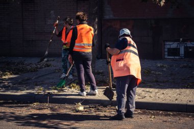 Kharkiv, Ukrayna, 16 Eylül 2025 Temizlik işçileri, Rus Şahin İHA 'sının bir binaya çarptığı sokakta karşılık veriyor. Hasar büyüktü ve bina alev aldı..