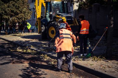 Kharkiv, Ukrayna, 16 Eylül 2025 Temizlik işçileri, Rus Şahin İHA 'sının bir binaya çarptığı sokakta karşılık veriyor. Hasar büyüktü ve bina alev aldı..
