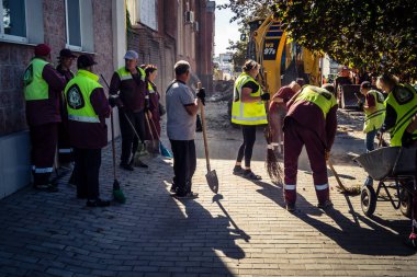 Kharkiv, Ukrayna, 16 Eylül 2025 Temizlik işçileri, Rus Şahin İHA 'sının bir binaya çarptığı sokakta karşılık veriyor. Hasar büyüktü ve bina alev aldı..