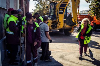 Kharkiv, Ukrayna, 16 Eylül 2025 Temizlik işçileri, Rus Şahin İHA 'sının bir binaya çarptığı sokakta karşılık veriyor. Hasar büyüktü ve bina alev aldı..