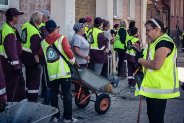 Kharkiv, Ukrayna, 16 Eylül 2025 Temizlik işçileri, Rus Şahin İHA 'sının bir binaya çarptığı sokakta karşılık veriyor. Hasar büyüktü ve bina alev aldı..