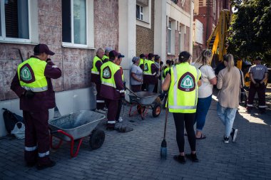 Kharkiv, Ukrayna, 16 Eylül 2025 Temizlik işçileri, Rus Şahin İHA 'sının bir binaya çarptığı sokakta karşılık veriyor. Hasar büyüktü ve bina alev aldı..