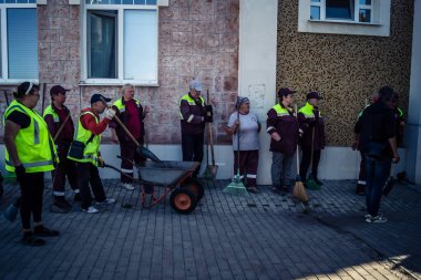 Kharkiv, Ukrayna, 16 Eylül 2025 Temizlik işçileri, Rus Şahin İHA 'sının bir binaya çarptığı sokakta karşılık veriyor. Hasar büyüktü ve bina alev aldı..