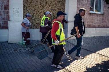 Kharkiv, Ukrayna, 16 Eylül 2025 Temizlik işçileri, Rus Şahin İHA 'sının bir binaya çarptığı sokakta karşılık veriyor. Hasar büyüktü ve bina alev aldı..