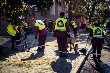 Kharkiv, Ukrayna, 16 Eylül 2025 Temizlik işçileri, Rus Şahin İHA 'sının bir binaya çarptığı sokakta karşılık veriyor. Hasar büyüktü ve bina alev aldı..