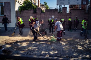 Kharkiv, Ukrayna, 16 Eylül 2025 Temizlik işçileri, Rus Şahin İHA 'sının bir binaya çarptığı sokakta karşılık veriyor. Hasar büyüktü ve bina alev aldı..