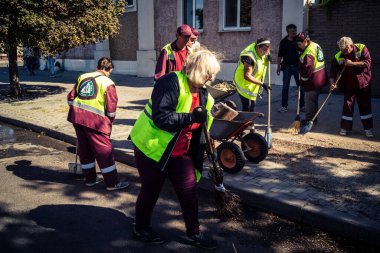 Kharkiv, Ukrayna, 16 Eylül 2025 Temizlik işçileri, Rus Şahin İHA 'sının bir binaya çarptığı sokakta karşılık veriyor. Hasar büyüktü ve bina alev aldı..