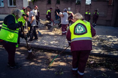 Kharkiv, Ukrayna, 16 Eylül 2025 Temizlik işçileri, Rus Şahin İHA 'sının bir binaya çarptığı sokakta karşılık veriyor. Hasar büyüktü ve bina alev aldı..