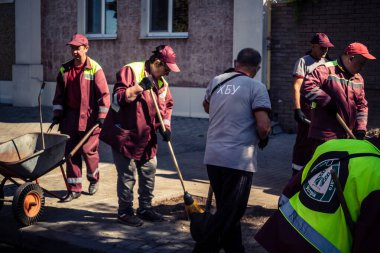 Kharkiv, Ukrayna, 16 Eylül 2025 Temizlik işçileri, Rus Şahin İHA 'sının bir binaya çarptığı sokakta karşılık veriyor. Hasar büyüktü ve bina alev aldı..