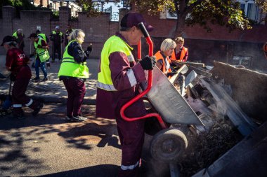 Kharkiv, Ukrayna, 16 Eylül 2025 Temizlik işçileri, Rus Şahin İHA 'sının bir binaya çarptığı sokakta karşılık veriyor. Hasar büyüktü ve bina alev aldı..