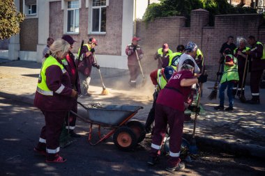 Kharkiv, Ukrayna, 16 Eylül 2025 Temizlik işçileri, Rus Şahin İHA 'sının bir binaya çarptığı sokakta karşılık veriyor. Hasar büyüktü ve bina alev aldı..