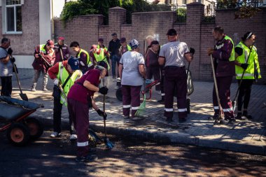 Kharkiv, Ukrayna, 16 Eylül 2025 Temizlik işçileri, Rus Şahin İHA 'sının bir binaya çarptığı sokakta karşılık veriyor. Hasar büyüktü ve bina alev aldı..