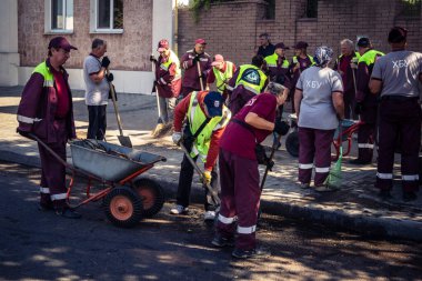 Kharkiv, Ukrayna, 16 Eylül 2025 Temizlik işçileri, Rus Şahin İHA 'sının bir binaya çarptığı sokakta karşılık veriyor. Hasar büyüktü ve bina alev aldı..