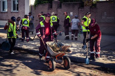 Kharkiv, Ukrayna, 16 Eylül 2025 Temizlik işçileri, Rus Şahin İHA 'sının bir binaya çarptığı sokakta karşılık veriyor. Hasar büyüktü ve bina alev aldı..