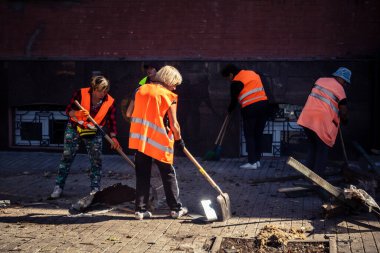 Kharkiv, Ukrayna, 16 Eylül 2025 Temizlik işçileri, Rus Şahin İHA 'sının bir binaya çarptığı sokakta karşılık veriyor. Hasar büyüktü ve bina alev aldı..