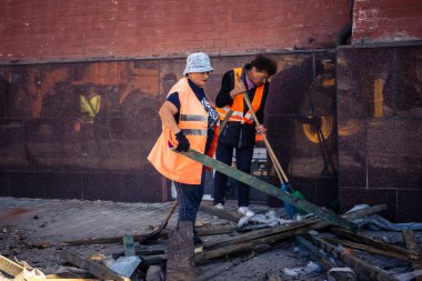 Kharkiv, Ukrayna, 16 Eylül 2025 Temizlik işçileri, Rus Şahin İHA 'sının bir binaya çarptığı sokakta karşılık veriyor. Hasar büyüktü ve bina alev aldı..