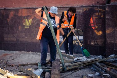 Kharkiv, Ukrayna, 16 Eylül 2025 Temizlik işçileri, Rus Şahin İHA 'sının bir binaya çarptığı sokakta karşılık veriyor. Hasar büyüktü ve bina alev aldı..
