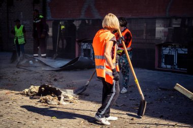 Kharkiv, Ukrayna, 16 Eylül 2025 Temizlik işçileri, Rus Şahin İHA 'sının bir binaya çarptığı sokakta karşılık veriyor. Hasar büyüktü ve bina alev aldı..