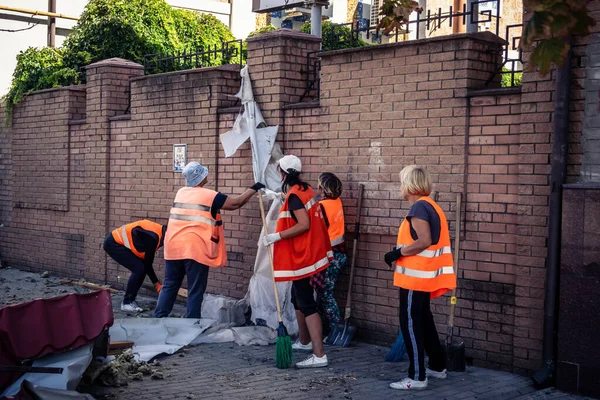 Kharkiv, Ukrayna, 16 Eylül 2025 Temizlik işçileri, Rus Şahin İHA 'sının bir binaya çarptığı sokakta karşılık veriyor. Hasar büyüktü ve bina alev aldı..