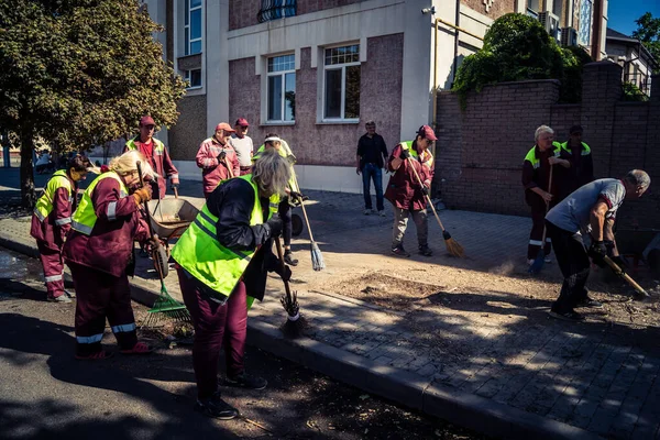 Kharkiv, Ukrayna, 16 Eylül 2025 Temizlik işçileri, Rus Şahin İHA 'sının bir binaya çarptığı sokakta karşılık veriyor. Hasar büyüktü ve bina alev aldı..