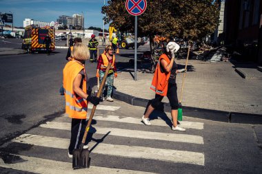 Kharkiv, Ukrayna, 16 Eylül 2025 Temizlik işçileri, Rus Şahin İHA 'sının bir binaya çarptığı sokakta karşılık veriyor. Hasar büyüktü ve bina alev aldı..