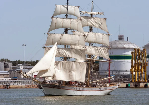 Old sailing ship in the background of an oil terminal