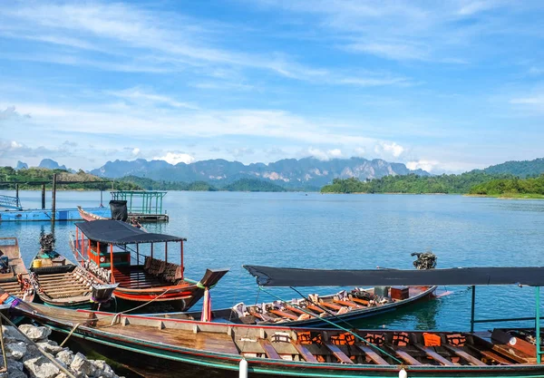 Ahşap Tay geleneksel uzun kuyruk tekne dağlar ve yağmur ormanı Ratchaprapha Barajı Khao Sok Milli Parkı, Surat Thani Eyaleti, Tayland, Thailand, güneşli bir gün sırasında arka planda bir gölde
