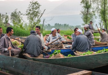 Srinagar, Hindistan - 25 Nisan, 2017: Keşmir adam üretmek Dal göle yüzen Pazar sabah erken alarak.