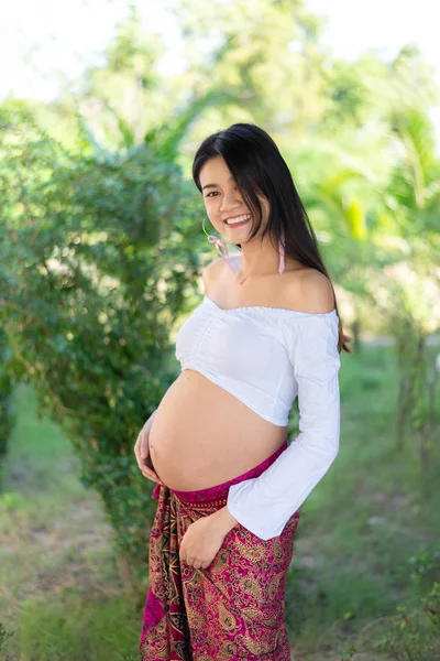 Joven asiática hermosa embarazada mujer en vestido blanco tocando su vientre —  Fotos de Stock