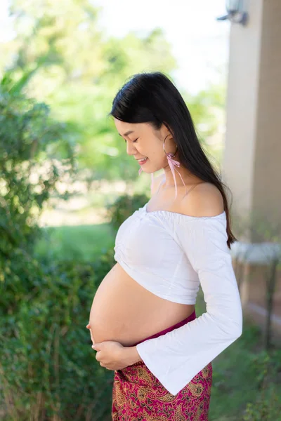 Jovem Asiática bela mulher grávida em vestido branco tocando sua barriga — Fotografia de Stock