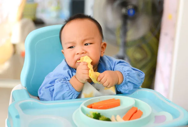 Азиатский мальчик 6 месяцев, питающийся методом Baby Led Weaning (BLW), самокормление — стоковое фото