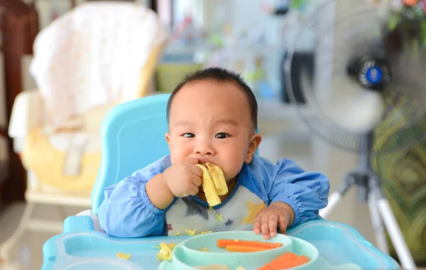 Азиатский мальчик 6 месяцев, питающийся методом Baby Led Weaning (BLW), самокормление — стоковое фото