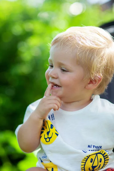 Emocional retrato de niño en el parque con árboles verdes en el fondo — Foto de Stock