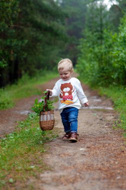 Güzel bir çocuk ile bir sepet çiçek bir güneşli yaz günü arka yolda