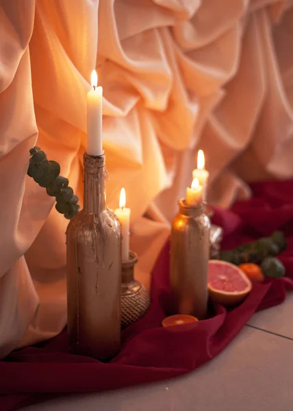 Candle in the bottle. Rose petals. — Stock Photo, Image