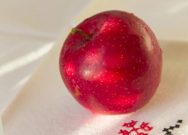 红色成熟苹果躺在亚麻餐巾与刺绣 — 图库照片