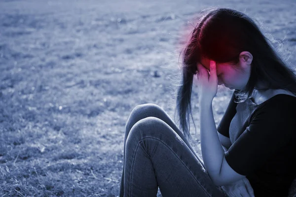 Frau Sitzt Auf Dem Gras Und Leidet Unter Kopfschmerzen — Stockfoto