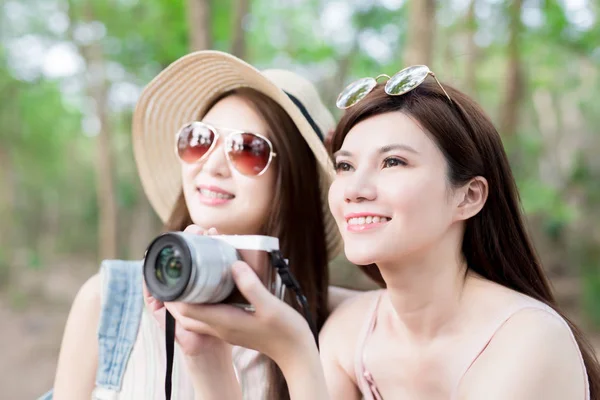 two beautiful  women with  camera in the forest