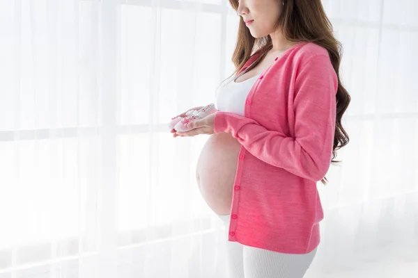 Pregnant Woman Standing Holding Small Baby Shoes — Stock Photo, Image