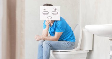 man with card  feeling  pain with constipation in toilet clipart