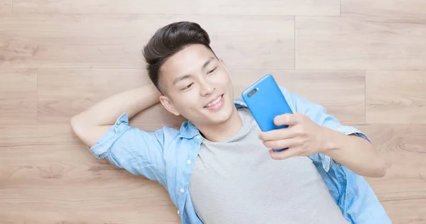 Man Using Phone Happily Lying Floor — Stock Photo, Image