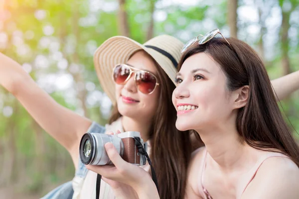 two beauty women with camera  in the forest