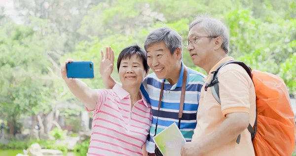 old traveling  people taking selfie happily in the park