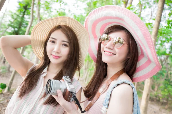 two beauty women with camera  in the forest