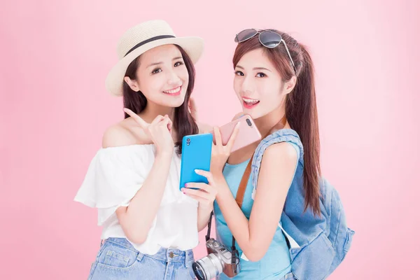 Två Resor Kvinnor Med Smartphones Den Rosa Bakgrunden — Stockfoto
