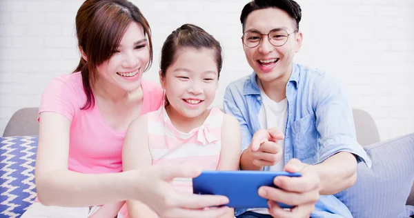 Famille Assise Sur Canapé Utilisant Téléphone Heureusement Maison — Photo