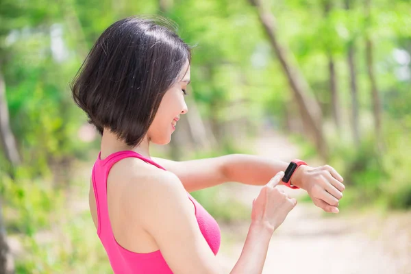 Donna Utilizzando Orologio Intelligente Indossabile Nella Foresta — Foto Stock